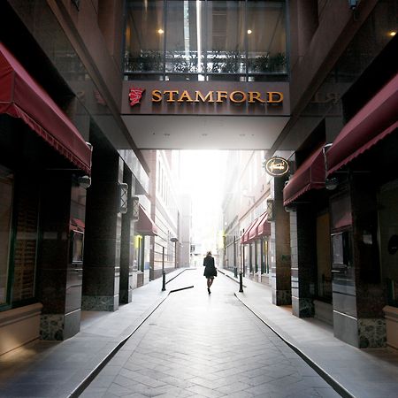 מלון Stamford Plaza מלבורן מראה חיצוני תמונה The photo depicts a narrow alley or passageway, possibly in an urban setting. On one side, there are storefronts with canopies, and on the opposite side, there is a prominent sign reading "STAMFORD." The pathway is lined with buildings, creating a se