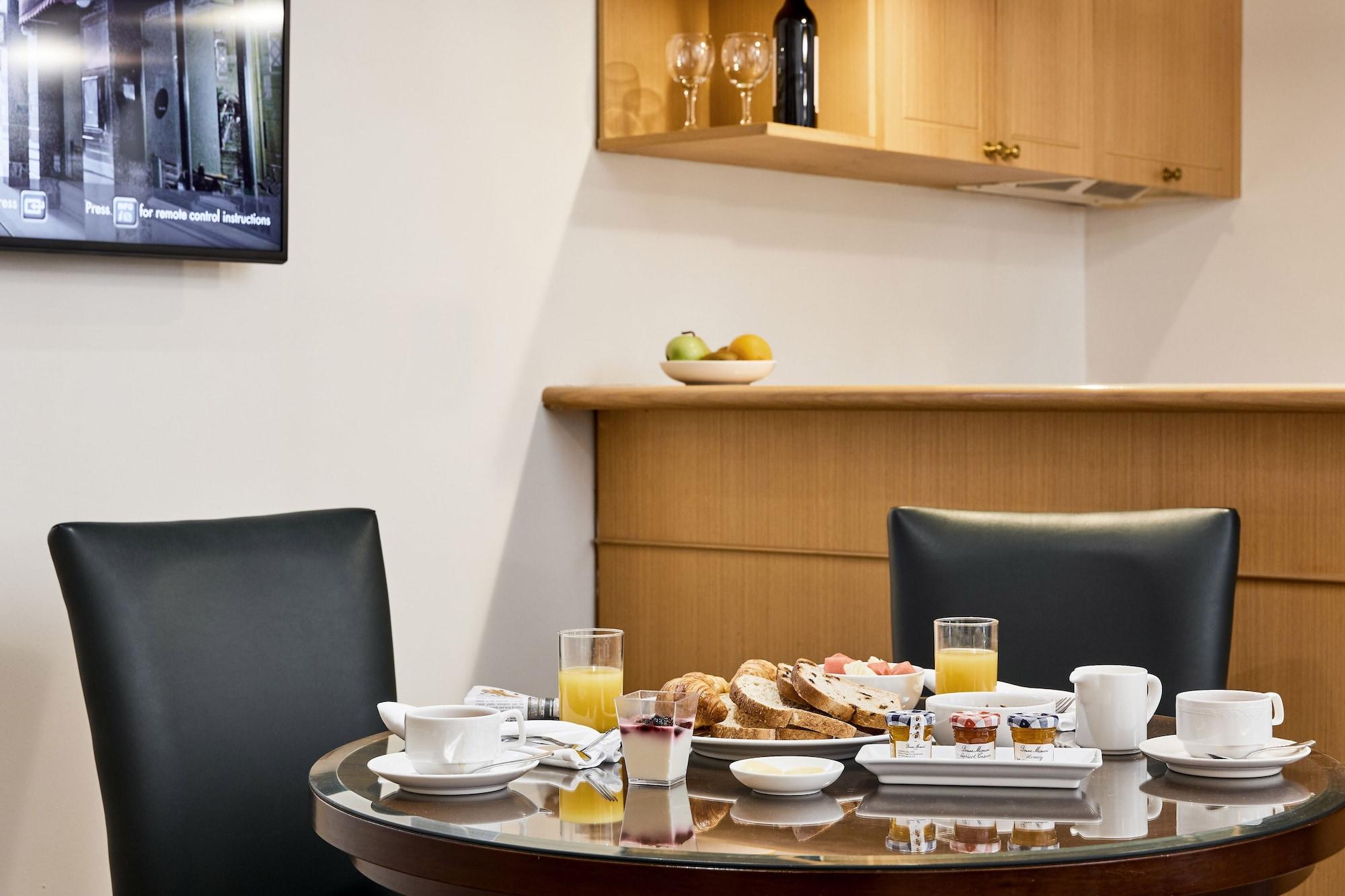 מלון Stamford Plaza מלבורן מראה חיצוני תמונה The photo shows a dining table set for breakfast or brunch. There are several food items displayed, including pastries and bread. Additionally, there are drinks, such as orange juice, served in glasses, and coffee in white cups. The table is round an