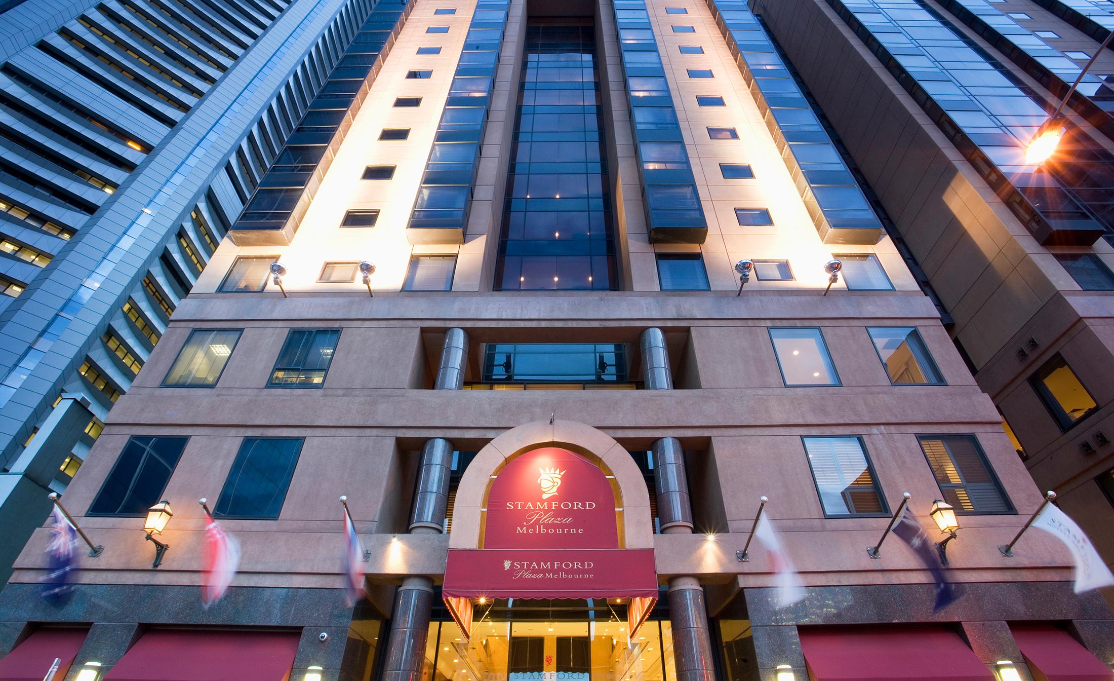 מלון Stamford Plaza מלבורן מראה חיצוני תמונה The photo shows the entrance of a modern hotel building. The architecture features a tall structure with glass and stone elements. The hotel's name is visible above the entrance, which is framed by an arch, and the facade includes multiple levels wit