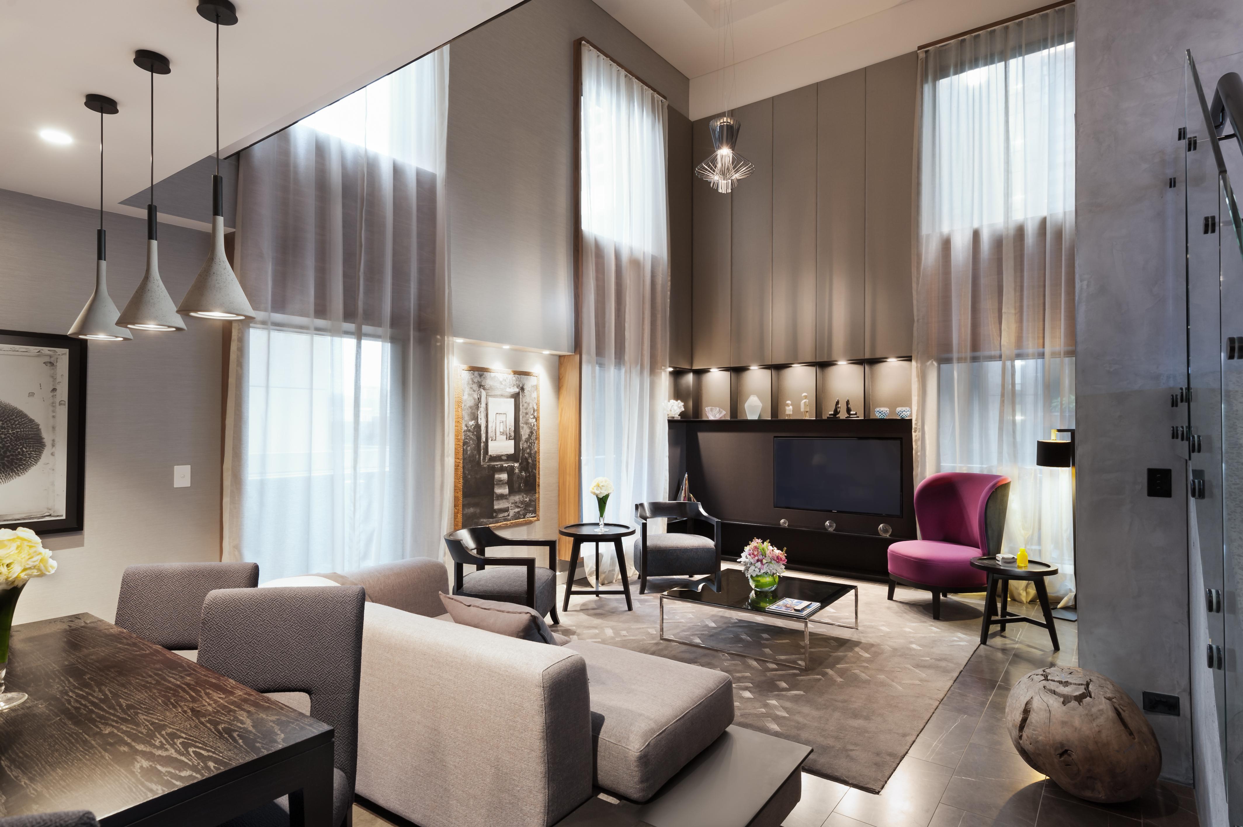 מלון Stamford Plaza מלבורן מראה חיצוני תמונה The photo shows a stylish and modern living room with high ceilings and large windows that allow natural light to brighten the space. The room features a mix of contemporary furniture, including a light gray sofa and a sleek coffee table in the cente