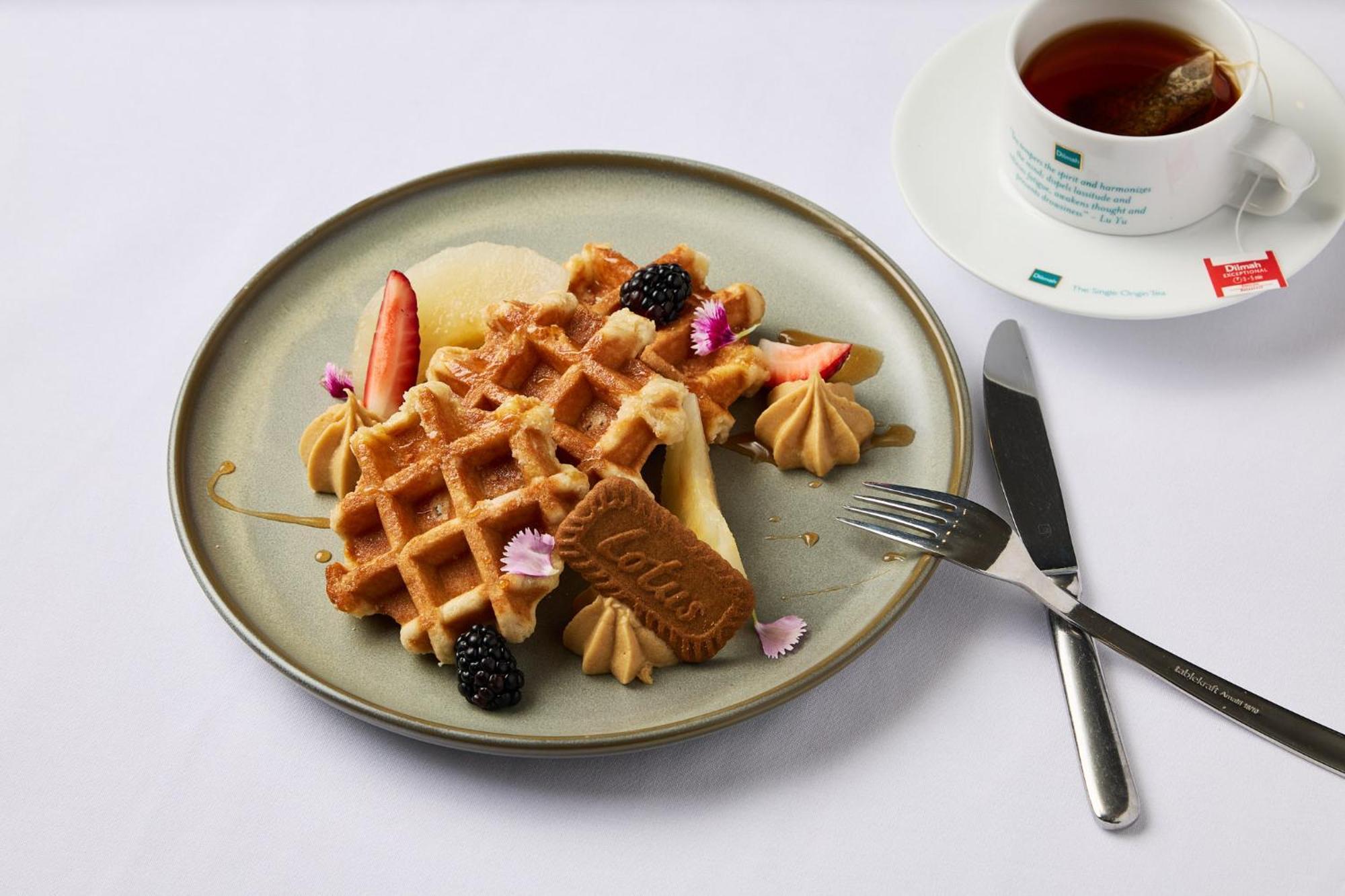 מלון Stamford Plaza מלבורן מראה חיצוני תמונה The photo depicts a beautifully arranged plate of waffles. The waffles are topped with a variety of accompaniments including slices of fresh fruit, blackberries, and small dollops of cream or mousse. A decorative cookie is placed on the waffles, addi