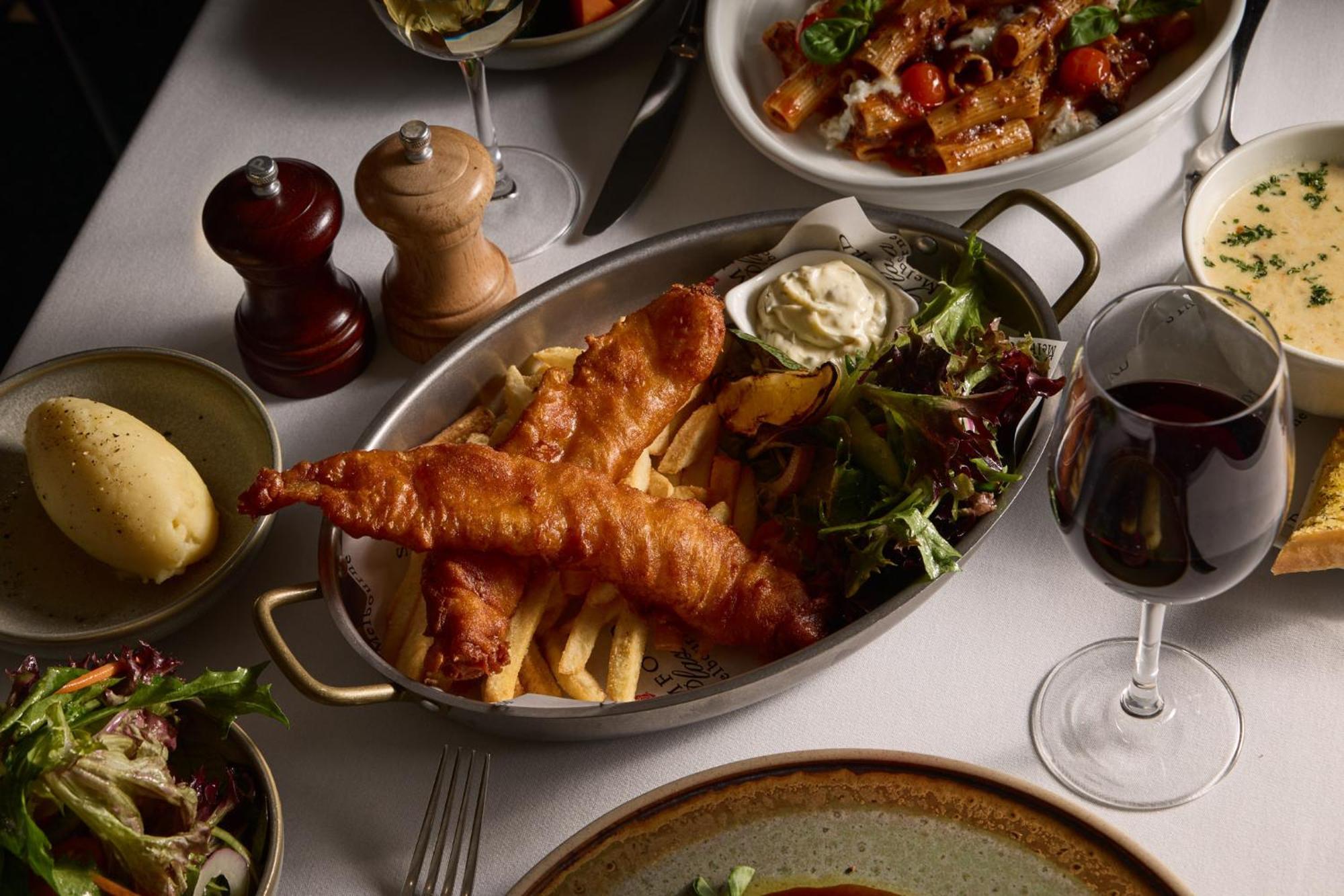 מלון Stamford Plaza מלבורן מראה חיצוני תמונה The photo showcases a beautifully arranged meal. In the foreground, there are two pieces of golden-battered fish served with crispy fries. Accompanying the fish is a small dollop of creamy sauce and a side salad, which has a mix of greens. Surroundin