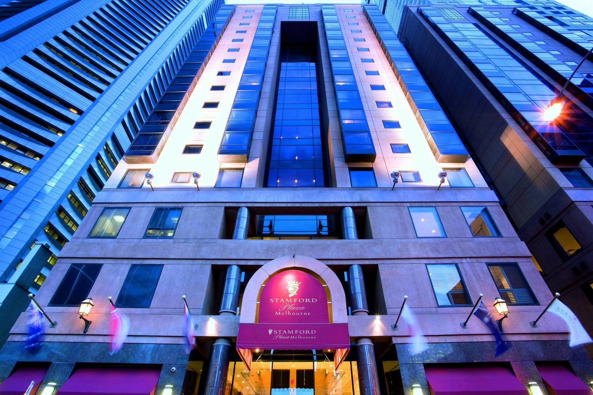מלון Stamford Plaza מלבורן מראה חיצוני תמונה The photo shows the exterior of a hotel, likely a luxury or high-end establishment. The building features a modern architectural design with a combination of glass and stone. The entrance is marked by a prominent sign, and the facade is illuminated, 